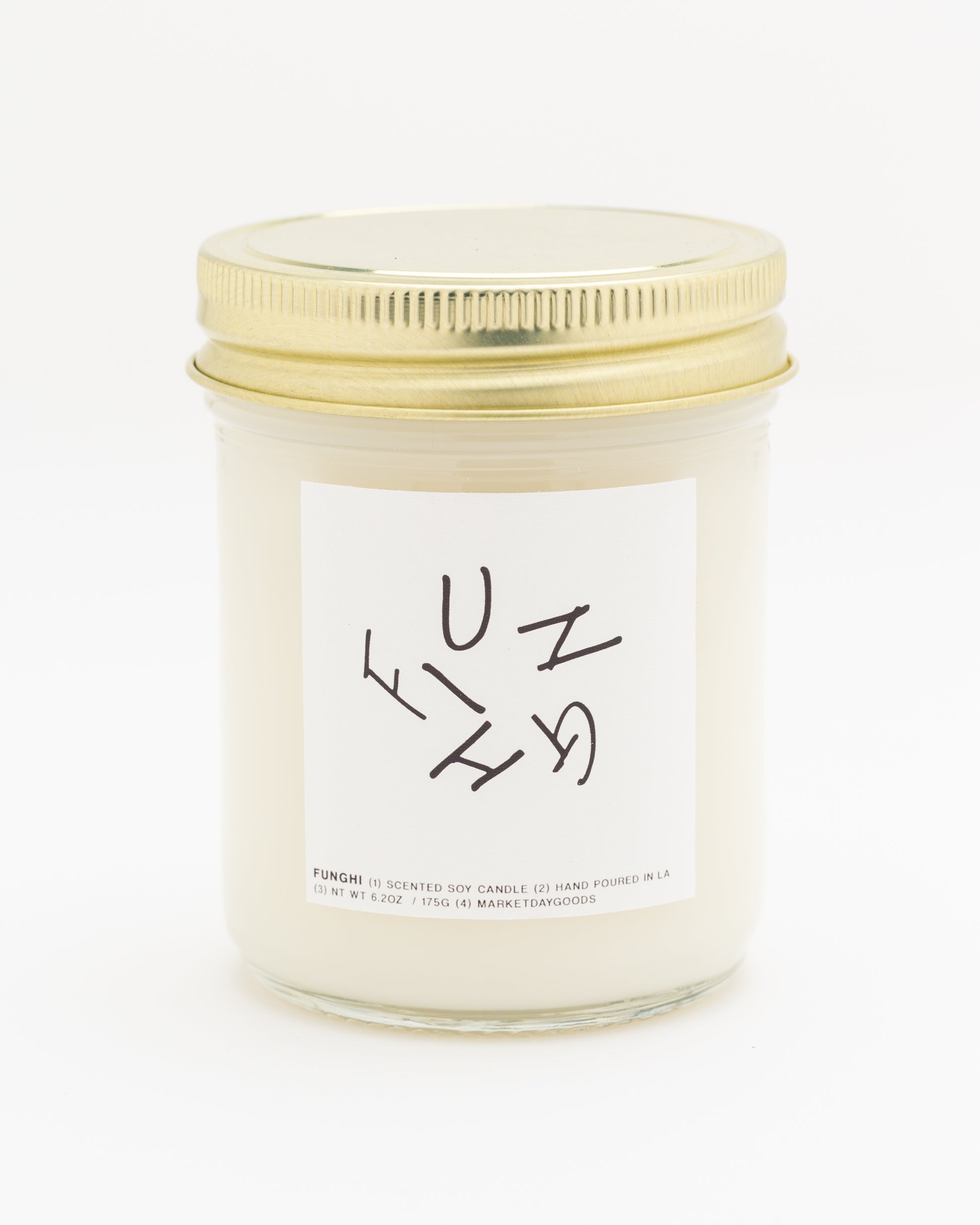 soy candle with gold lid and white label on a white background