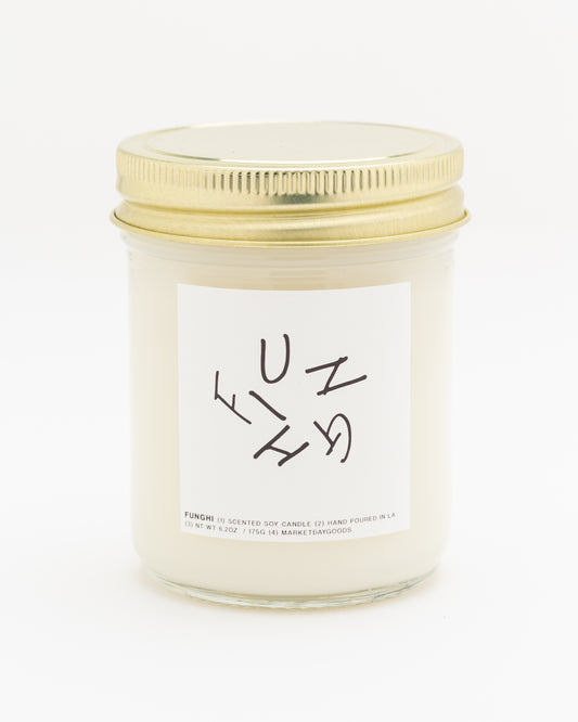 soy candle with gold lid and white label on a white background